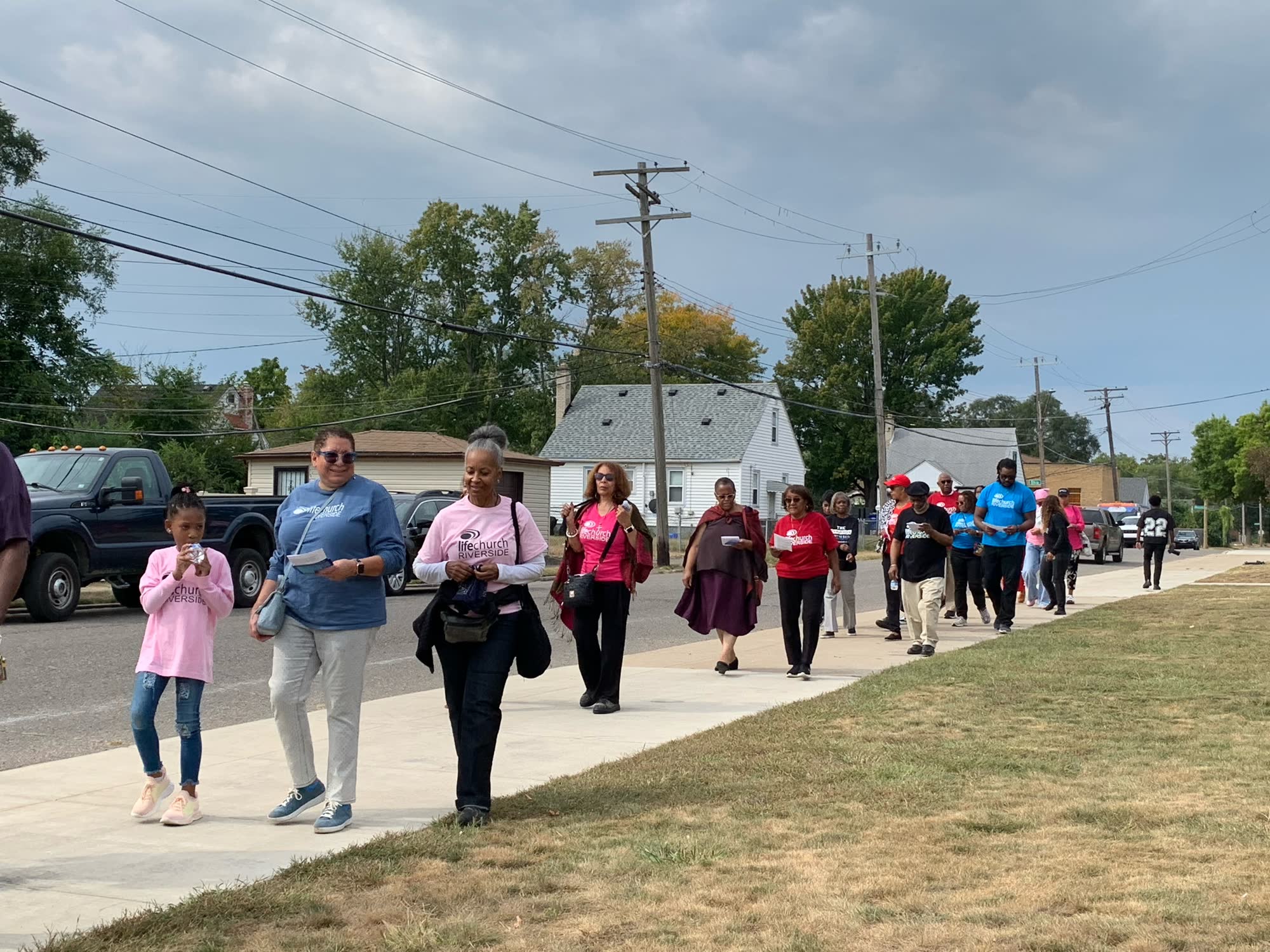 LifeChurch Riverside members walking together through the neighborhood in church shirts on a prayer walk